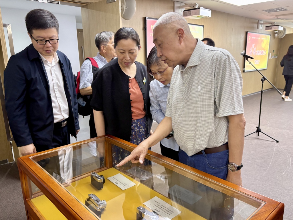 1750217081562482.jpg 上海市华侨摄影协会副会长马正康(右一)介绍收藏的海鸥牌相机。.jpg